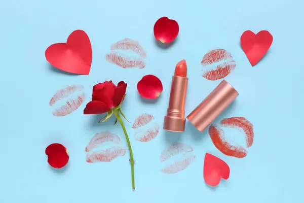 Lipstick with kisses and red rose on blue background