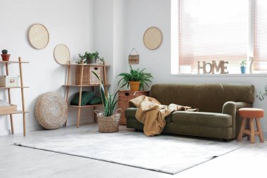 Hasır kapta kanepe ve çiçek bulunan şık bir oturma odası.