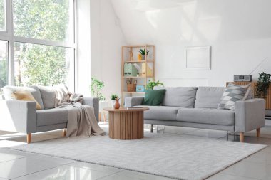 Oturma odasının içinde kanepeler ve rattan masa var.