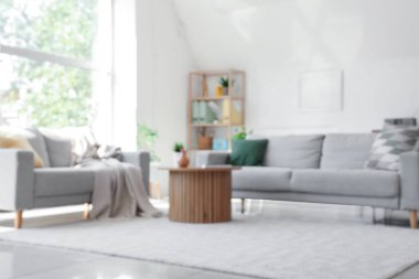 Oturma odasının bulanık manzarası, kanepeler ve rattan masa.