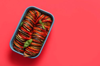 Kırmızı arka planda lezzetli Ratatouille yemeği.