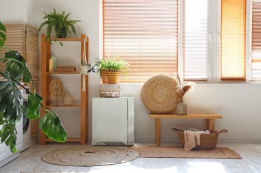 Çamaşır makinesi ve bitkileri olan şık bir çamaşırhane.