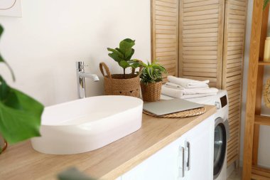 Lavabo ve dizüstü bilgisayarlı ahşap tezgah, yakın plan.