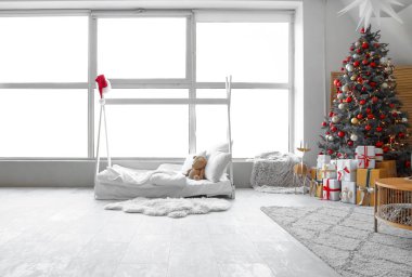Süslü Noel ağacı ve hediye kutuları olan neşeli çocukların yatak odasının içi.