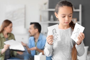 Evde aile resimlerini çizen üzgün küçük bir kız. Boşanma kavramı