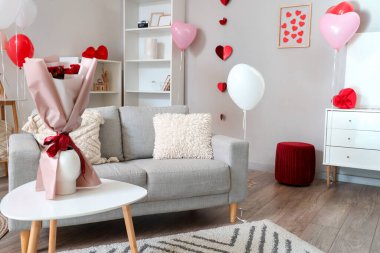 Sevgililer Günü için dekore edilmiş aydınlık oturma odasının içi kanepe, kalp ve balonlarla dolu.