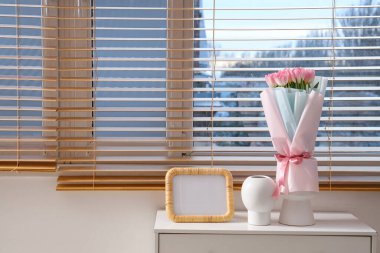 Sevgililer Günü için dekore edilmiş odalardaki çekmecelerin üzerinde güller ve boş çerçeveli vazolar.