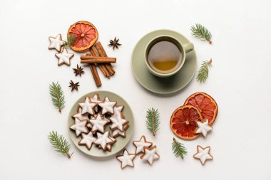 Lezzetli yıldızlı kompozisyon Noel kurabiyeleri, bir fincan çay, baharatlar ve arka planda köknar ağacı dalları