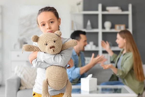 Sad little girl with toy bear at home. Divorce concept