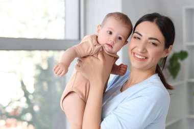 Mutlu anne ve küçük bebeği yatak odasında.