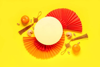 Sarı arka planda Çin sembolleri, mandalina ve fal kurabiyeleri olan boş bir kart. Yeni yıl kutlaması