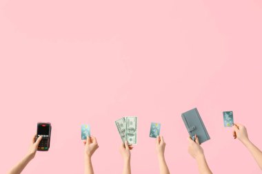 Pembe arka planda kredi kartı, ödeme terminali, cüzdan ve dolar banknotu olan kadınlar