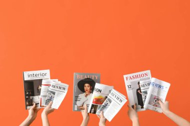 Turuncu arka planda gazete ve dergileri olan kadınlar