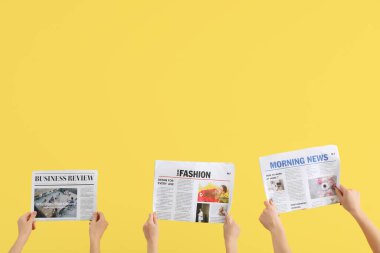 Sarı arka planda gazetesi olan kadınlar