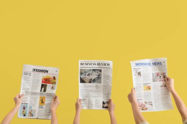 Sarı arka planda gazetesi olan kadınlar