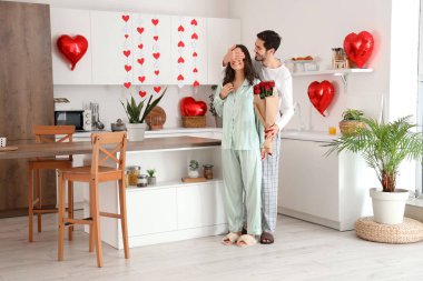 Sevgililer Günü 'nde karısını güllerle karşılayan mutlu bir genç adam.