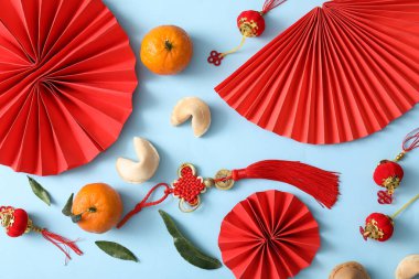 Mavi arka planda kağıt yelpaze, mandalina ve Çin sembolleri olan kompozisyon. Yeni yıl kutlaması