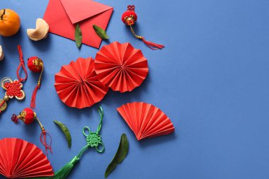 Mavi arka planda kağıt yelpaze, mandalina ve Çin sembolleri olan kompozisyon. Yeni yıl kutlaması