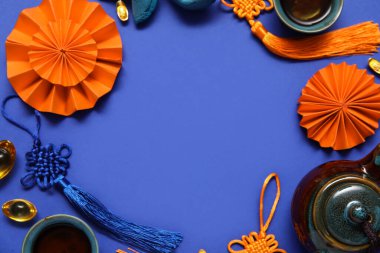 Çaydanlıktan yapılmış çerçeve, çay fincanları ve mavi arkaplanda farklı Çin sembolleri. Yeni yıl kutlaması