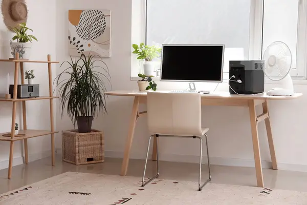 Comfortable workspace with modern computer and portable power station in contemporary room