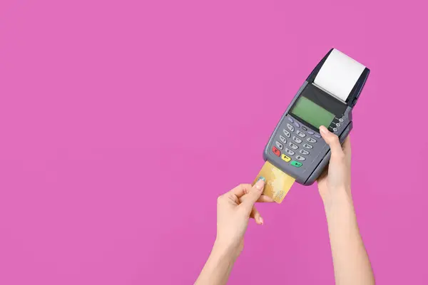 Woman with credit card and payment terminal on purple background