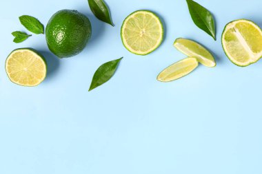 Mavi arka planda yaprakları olan taze limon dilimleri