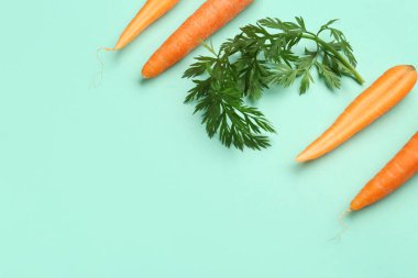 Turkuaz arka planda taze havuç ve dilimler.