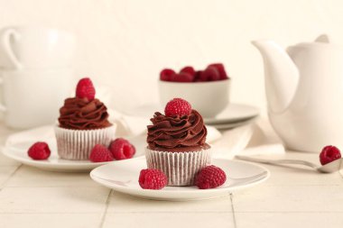 Tabaklar dolusu lezzetli çikolatalı kek ve masada ahududu.