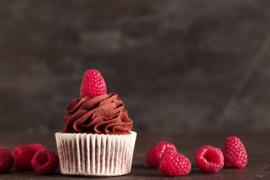 Siyah arka planda ahududu olan lezzetli çikolatalı kek.