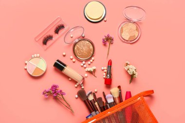 Makyaj ürünleri ve mercan zemin üzerinde güzel çiçekler olan şık kırmızı kozmetik çanta.