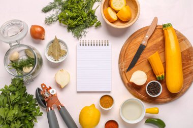 Boş tarif kitabıyla kompozisyon, taze sebzeler ve hafif arka planda baharatlar
