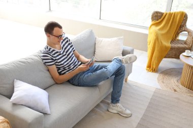 Genç adam evdeki kanepede para sayıyor.