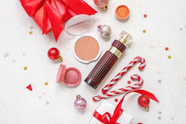 Parfümlü makyaj ürünleri ve beyaz grunge arka planda Noel dekoru.