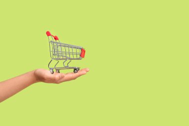 Arka planda kırmızı alışveriş arabası olan bir kadın..