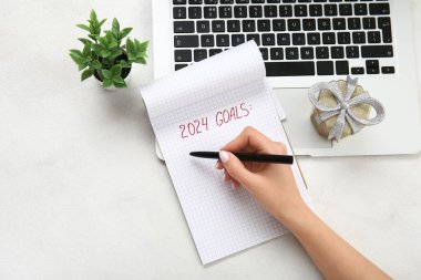 Beyaz grunge arka planda dizüstü bilgisayarda 2024 gol yazan kadın