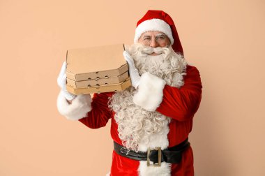 Bej arka planda pizza kutularıyla Noel Baba