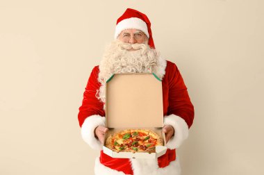Beyaz arka planda bir kutu lezzetli pizza olan Noel Baba.