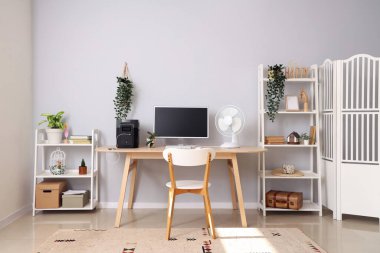 Modern bilgisayarlı rahat çalışma alanı ve çağdaş odada taşınabilir güç istasyonu