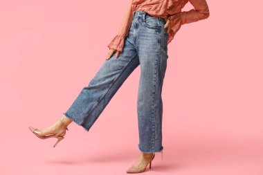 Pembe arka planda şık kotlu güzel Asyalı kadın, yakın plan.