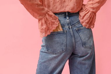 Pembe arka planda şık kotlu güzel bir Asyalı kadın.