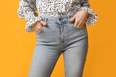 Sarı arka planda şık kotlu güzel Asyalı kadın, yakın plan.