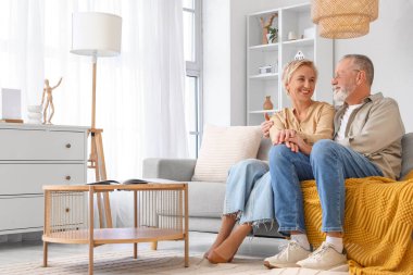 Evde koltukta oturan olgun bir çift.