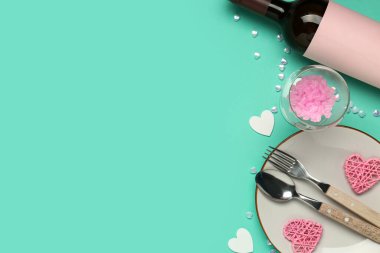 Kalpler ve turkuaz arka planda bir şişe şarapla güzel bir masa. Sevgililer Günü kutlaması