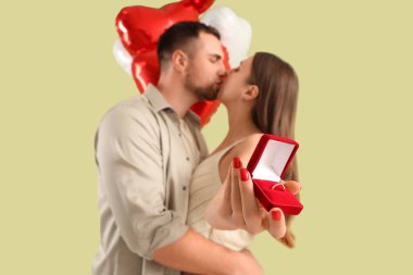 Lovely couple with wedding ring and heart-shaped balloons kissing on green background. Valentine's Day celebration clipart