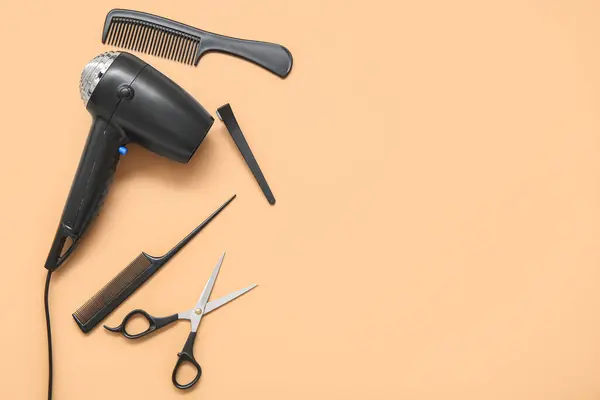 Different hairdressing tools on beige background