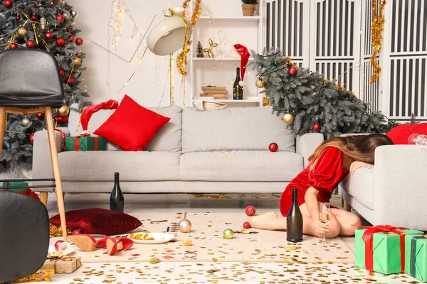 Drunk woman in messy living room after New Year party