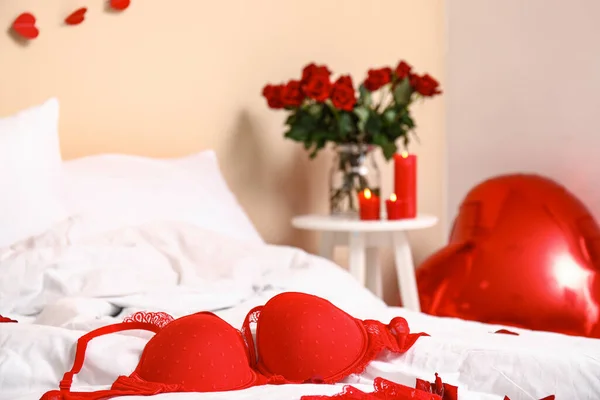 Interior of festive bedroom with different decorations and sexy underwear for Valentine\'s Day celebration