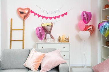 İçinde güller olan çekmeceler, yanan mumlar ve oturma odasında kalp şeklinde balonlar. Sevgililer Günü kutlaması