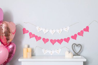 Yazılı kalp şeklinde çelenk Mutlu VALENTİN 'İN GÜNÜ oturma odasındaki beyaz duvarda asılı