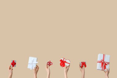 Bej arka planda hediye kutuları olan kadın elleri. Sevgililer Günü kutlaması